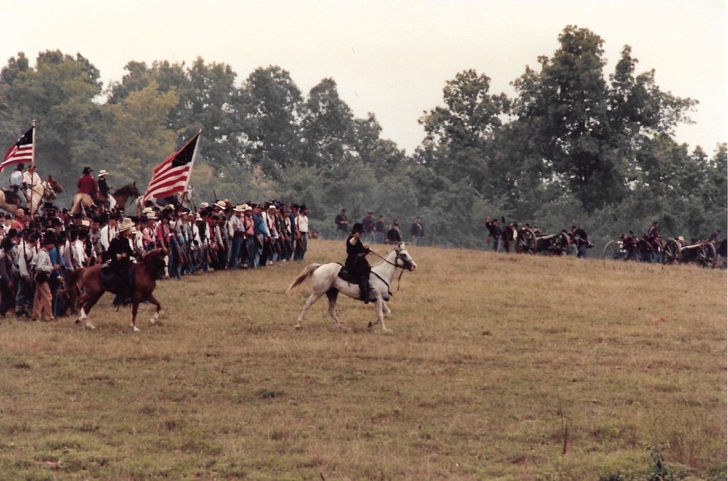 civil war re-enactors led by man on white horse
